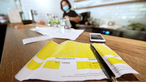 Ein Kontaktliste liegt auf einem Tresen in einem Restaurant. © picture alliance/dpa 