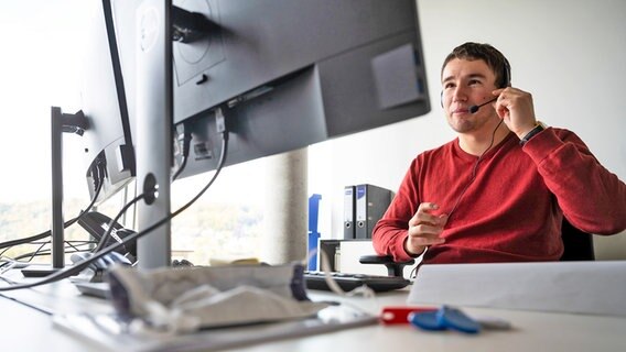 Ein Mann sitzt mit Headset vor einem Computerbildschirm (beschäftigt mit Kontaktnachverfolgung). © picture alliance/Marijan Murat/dpa Foto: Marijan Murat/dpa