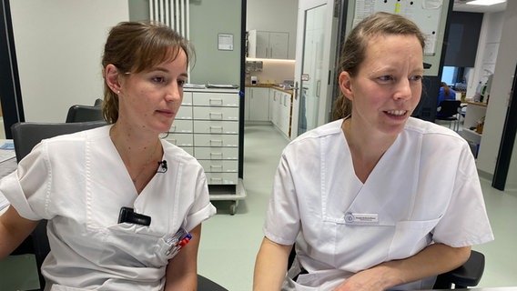 Pflegerin Natalie Neumann und Stationsleiterin Frauke Brömmelhaus schauen gemeinsam auf einen Bildschirm. © NDR Foto: Karoline Kempe