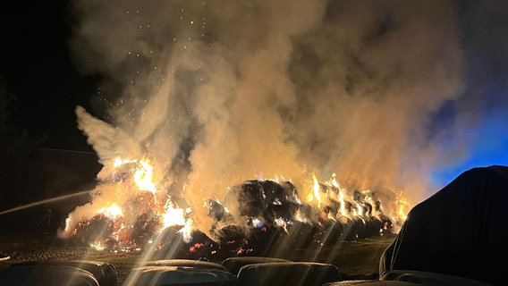 Flammen schlagen bei einem Feuer bei Lüneburg aus brennenden Strohballen. © Polizei Lüneburg 