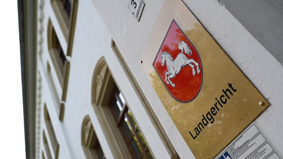 Ein Schild mit dem niedersächsischen Landeswappen hängt am Eingang zum Landgericht Aurich. © picture alliance/dpa | Lars Penning Foto: Lars Penning