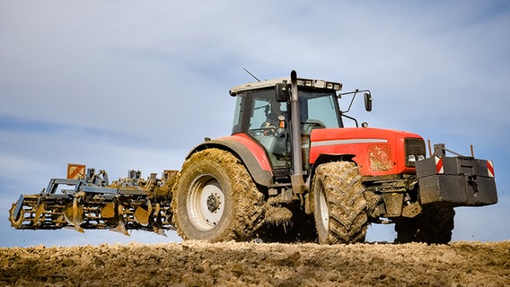 Ein Traktor mit einem Grubber steht auf einem Acker. © fotolia/countrypixel 