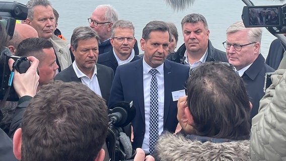 Minister Lies (SPD) steht beim Rammschlag des schwimmenden LNG-Terminals in Wilhelmshaven neben Robert Habeck (Grüne) und Bernd Althusmann (CDU). © Niedersächsisches Ministerium für Umwelt, Energie, Bauen und Klimaschutz 