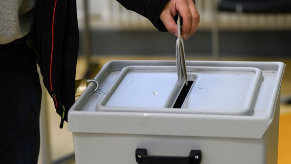 Ein Wähler gibt im Wahlraum des Felix-Klein-Gymnasium seine Stimme in einer Wahlurne ab. © Swen Pförtner/dpa Foto: Swen Pförtner/dpa