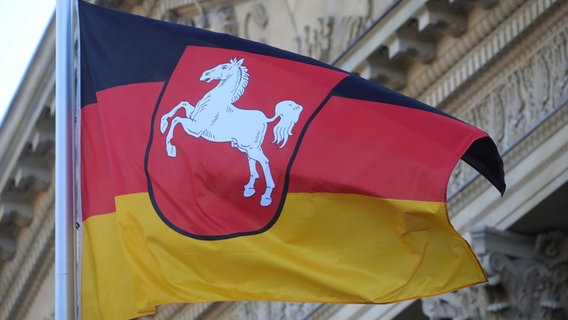 Eine Flagge mit dem Niedersachsenross weht vor dem Niedersächsischen Landtag. © picture alliance Foto: Michael Kappeler