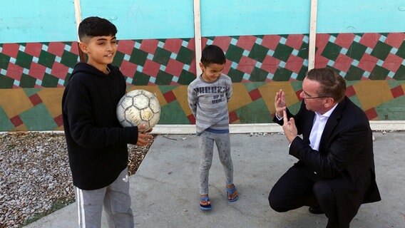Minister Pistorius (SPD) spricht mit zwei geflüchteten Kindern. © Niedersächsisches Ministerium für Inneres und Sport 