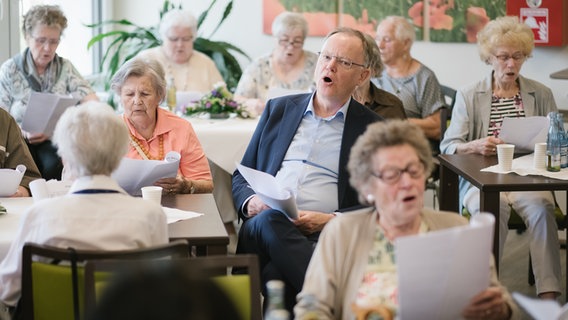 Ministerpräsident Stephan Weil (SPD) singt gemeinsam mit Seniorinnen. © Ole Spata Foto: Ole Spata