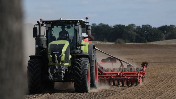 Ein Bauer fährt mit seinem Traktor über ein Feld. © picture alliance / dts-Agentur 