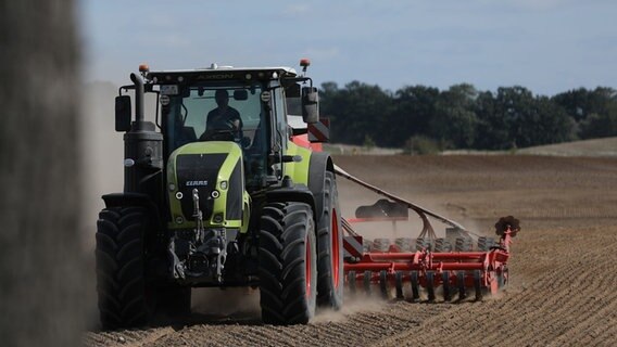 Ein Bauer fährt mit seinem Traktor über ein Feld. © picture alliance / dts-Agentur 