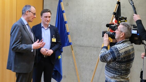 Sebastian Lechner (CDU) steht neben Friedrich Merz (CDU) vor einem Kamerateam. © NDR Foto: Torben Hildebrandt