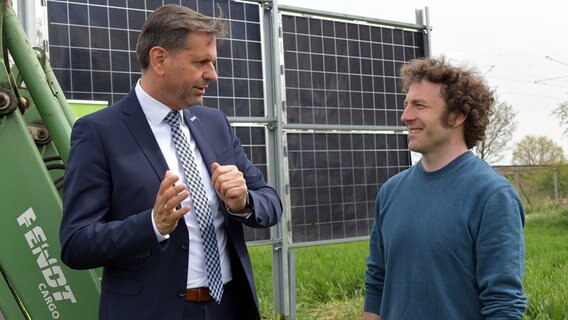 Niedersachsens Umweltminister Olaf Lies unterhält sich vor aufgestellten Solarmodulen mit Corbinian Scho·finiu von der Klimaschutz- und Energieagentur Landkreis Verden. © dpa-Bildfunk Foto: Michael Bahlo