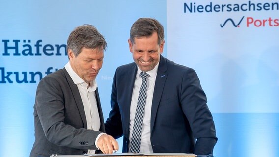 Robert Habeck (Bündnis 90/Die Grünen, l), Bundesminister für Wirtschaft, und Klimaschutz und Olaf Lies (SPD), Umweltminister von Niedersachsen, unterzeichnen die Vereinbarung zwischen Bund und Ländern über den Ausbau Wilhelmshavens grünen Energiedrehscheibe Deutschlands. © picture alliance/dpa | Sina Schuldt Foto: Sina Schuldt