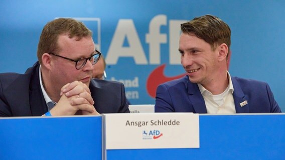 Ansgar Schledde (links), sellvertretender Landesvorsitzender, und Frank Rinck, Landesvorsitzender, (beide AfD) sitzen beim Landesparteitag der AfD Niedersachsen auf der Bühne. © dpa Foto: Georg Wendt
