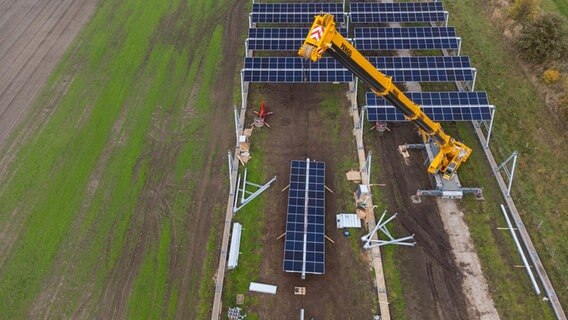 Mit einem Kran wird eine Agrar-Photovoltaik-Anlage montiert. © picture alliance/dpa Foto: Philipp Schulze