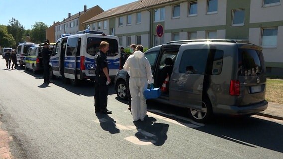 Polizeibeamte und Mitarbeitende der Spurensicherung stehen vor einem Wohnhaus. © TeleNewsNetwork 