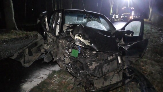 Ein stark beschädigtes Auto steht im Dunkeln an einer Straße. © TeleNewsNetwork 