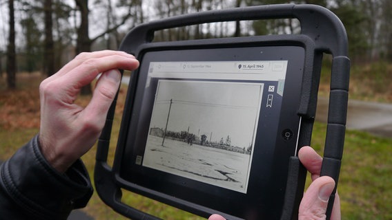 Auf einem iPad läuft das Bergen-Belsen-App und zeigt Fotos des Konzentrationslagers. © NDR Foto: Vassili Golod