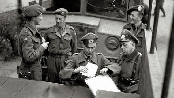 Offiziere der britischen Armee und der Wehrmacht verhandeln an einem Wagen. © picture alliance / Mary Evans Public Library 