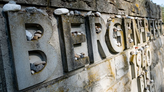 Kleine Steinchen liegen auf dem Schriftzug eines Gedenksteins während der Gedenkveranstaltung zum 75. Jahrestag der Befreiung des KZ Bergen-Belsen. © dpa - Bildfunk Foto: Peter Steffen