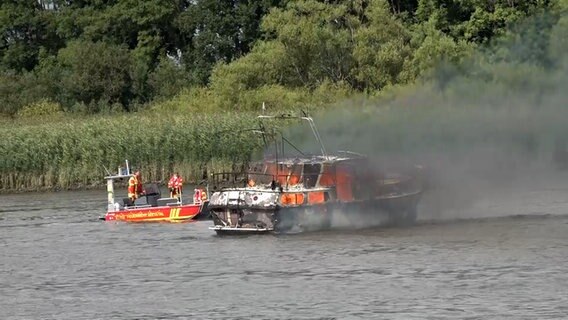 Ein Kajütboot treibt brennend auf der Elbe. © NonstopNews 