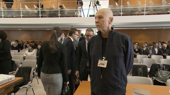 Hans-Jürgen Brennecke steht in einem Verhandlungssaal des Bundesverfassungsgerichts in Karlsruhe. © NDR 