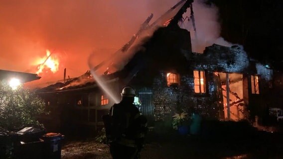 Feuerwehrleute löschen ein Reetdachhaus. © TV Elbnews 