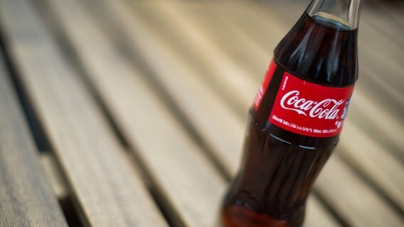 Eine Coca Cola-Flasche steht auf einem Tisch. © picture alliance / dpa Foto: Lukas Schulze