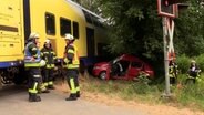 Ein Pkw steht nach einem Unfall neben einem Regionalzug. © NonstopNews 