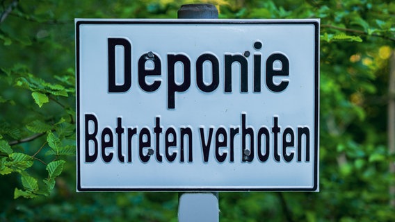 Das Bild zeigt ein Schild mit der Aufschrift "Deponie - Betreten verboten" in einem Wald. © picture alliance / Zoonar Foto: Bernd Brueggemann