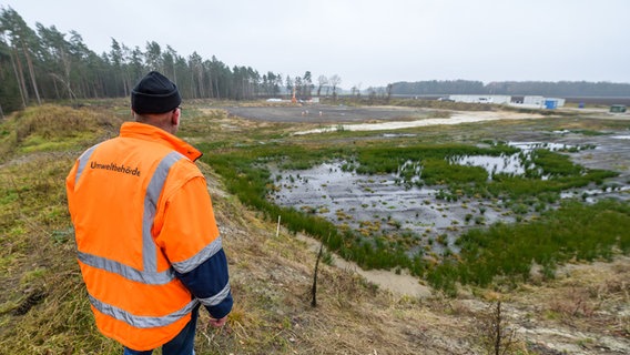 Ein Mitarbeiter der Umweltbehörde steht am Dethlinger Teich. © Picture Alliance Foto: Philipp Schulze