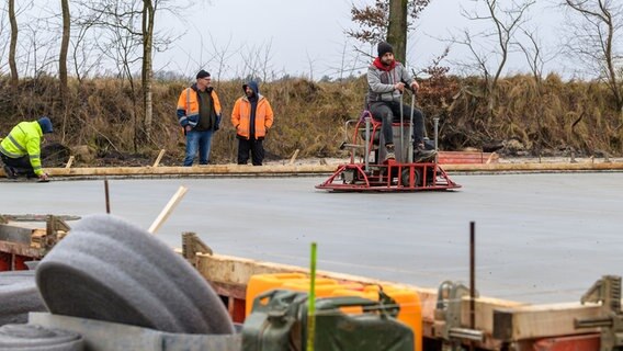 Mitarbeiter der Umweltbehörde stehen am Dethlinger Teich. © dpa-Bildfunk Foto: Philipp Schulze