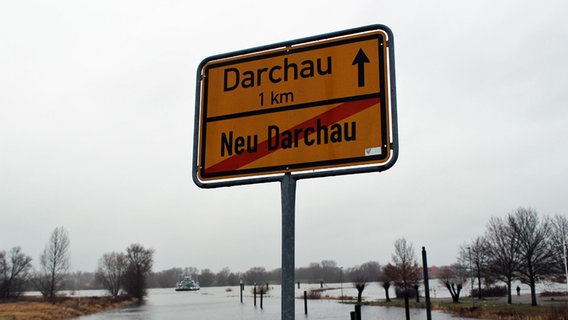 Ortsschild: Neu Darchau ist durchgestrichen. Darüber steht: "Darchau 1 km". © NDR Foto: Ann-Kristin Mennen