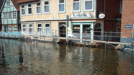 August 2002: Das Elbhochwasser hat die Innenstadt von Hitzacker erreicht. Die Fachwerkhäuser werden mit Baugerüsten, Sandsäcken und Planen vor den Wassermassen geschützt. © Stadt Hitzacker 