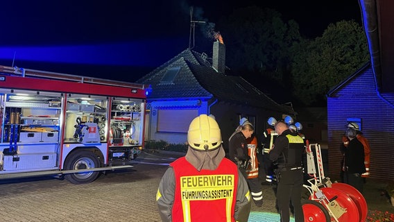 Einsatzkräfte der Feuerwehr stehen vor einem Wohnhaus. © Kreisfeuerwehr Rotenburg (Wümme) 