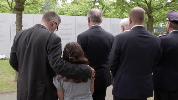 Gäste der Gedenkveranstaltung des Zugunglücks von Eschede stehen vor der Gedenkstätte. © NDR 