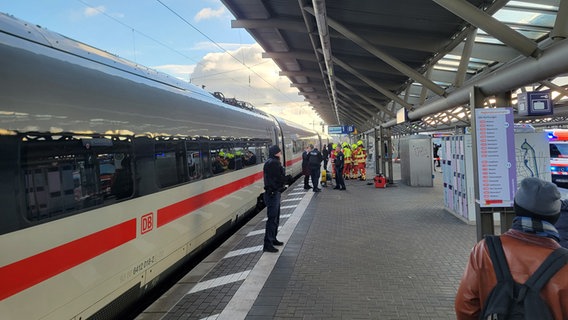 Einsatzkräfte stehen an einem Bahnsteig neben einem ICE. © NDR Foto: Kevin Poweska