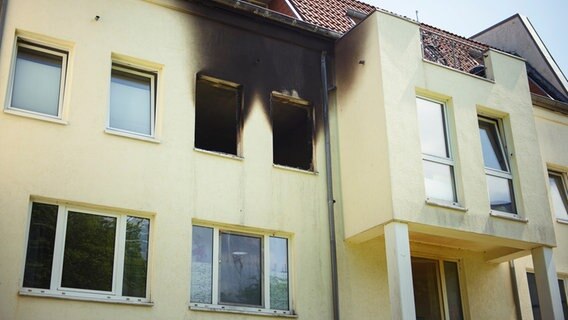 An der verkohlten Fassade ist in einem Mehrfamilienhaus im Lüneburger Stadtteil Weststadt nach einer Explosion eine ausgebrannte Wohnung zu erkennen. © dpa Foto: Gregor Fischer