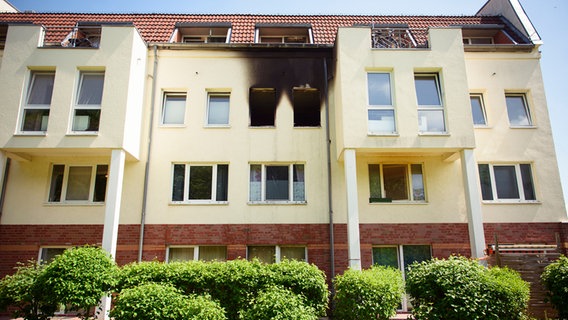 An der verkohlten Fassade ist in einem Mehrfamilienhaus im Lüneburger Stadtteil Weststadt nach einer Explosion eine ausgebrannte Wohnung zu erkennen. © dpa Foto: Gregor Fischer