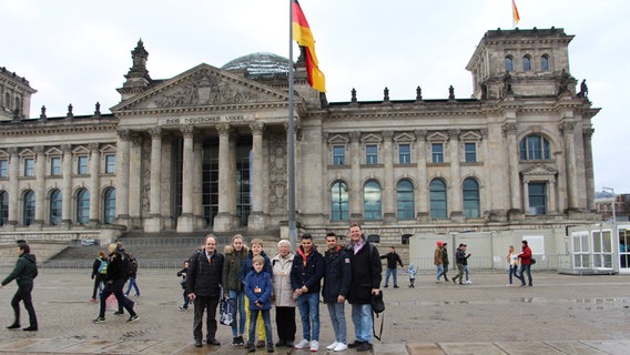Mit ihren Gastgroßeltern stehen Mohammad und Abdullah vor dem Reichstagsgebäude in Berlin. © NDR Foto: Christian Berndt