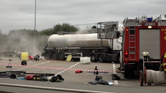 Ein Feuerwehrwagen steht neben einem Tanklaster an dem Dampf aufsteigt, der Bereich ist mit Flatterband abgesperrtn. © NonstopNews 