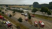 Luftaufnahme eines gesperrten Parkplatzes an der A1, auf dem Einsatzfahrzeuge neben einem Tanklaster stehen, an dem Dampf aufsteigt. © NonstopNews 