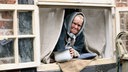 Eine alte Frau guckt aus einem Fenster. © NDR/ Martin Hutcheson Fotograf: Martin Hutcheson