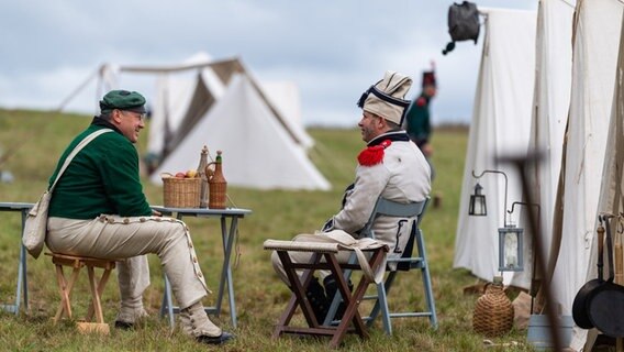 Als Soldaten verkleidete Darsteller der Göhrdeschlacht von 1813 sitzen im Lager. © Philipp Schulze/dpa Foto: Philipp Schulze