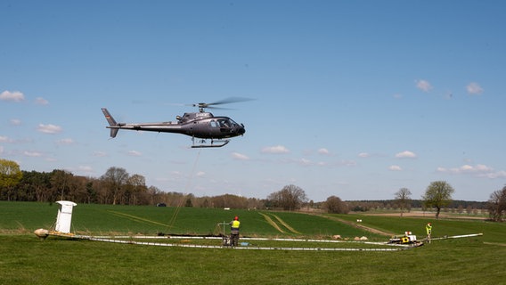 Eine Antenne, die an einem Hubschrauber hängt, wird vor der Landung abgesetzt. © dpa Foto: Philipp Schulze