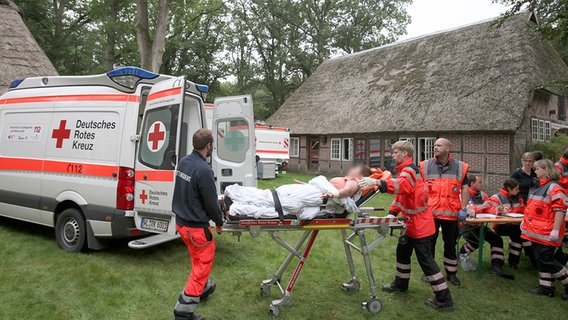 Sanitäter bringen eine verletzte Person auf einer Trage zu einem Rettungswagen. ©  dpa-Bildfunk Foto: Christian Butt