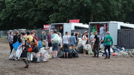 Festivalgänger warten mit Müllsäcken in einer Schlange. © NDR Foto: Adrian Lange