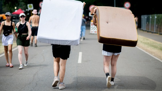 Zwei Besucherinnen gehen mit Matratzen zum Zeltplatz des Hurricane Festivals. © dpa-Bildfunk Foto: Hauke-Christian Dittrich