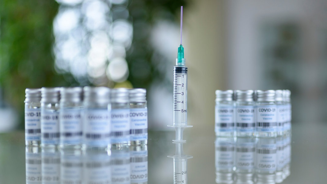 Impfmittel und Impfspritzen stehen auf einem Tisch.