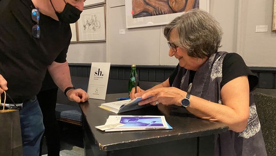 Judith Kalman signiert ihr Buch. © NDR Foto: Christina von Sass