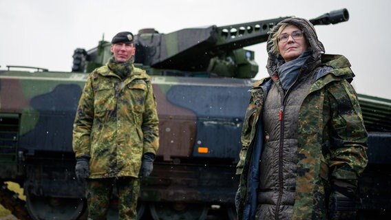 Christine Lambrecht (r, SPD), Verteidigungsministerin, lässt sich bei ihrem Besuch der Panzerlehrbrigade 9 einen Schützenpanzer vom Typ Puma erklären. © dpa Foto: Philipp Schulze